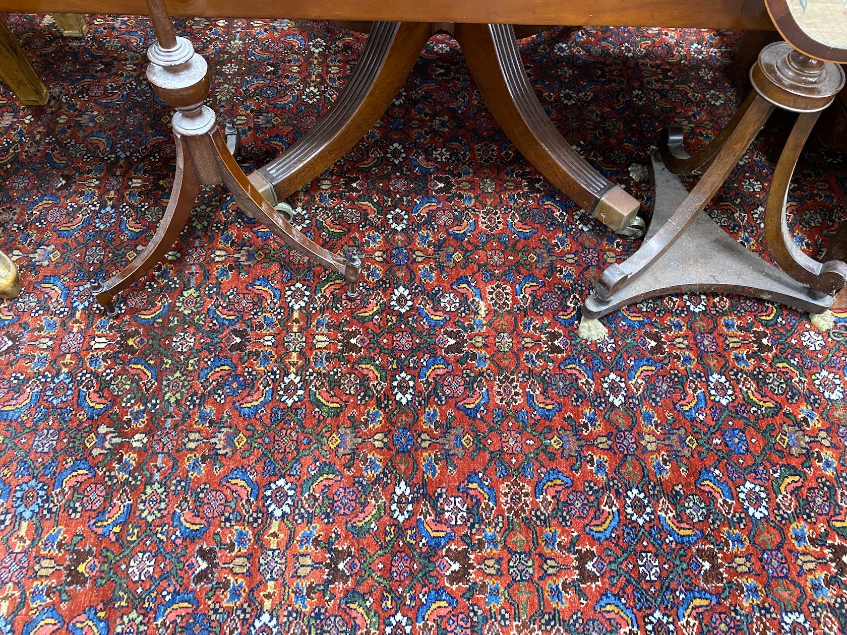 A North West Persian red ground carpet with dense floral field within a triple border, 360 x 250cm